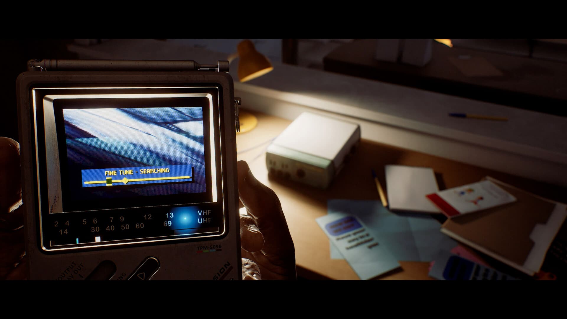 The CRTV screen reads FINE TUNE - SEARCHING above a desk of notes