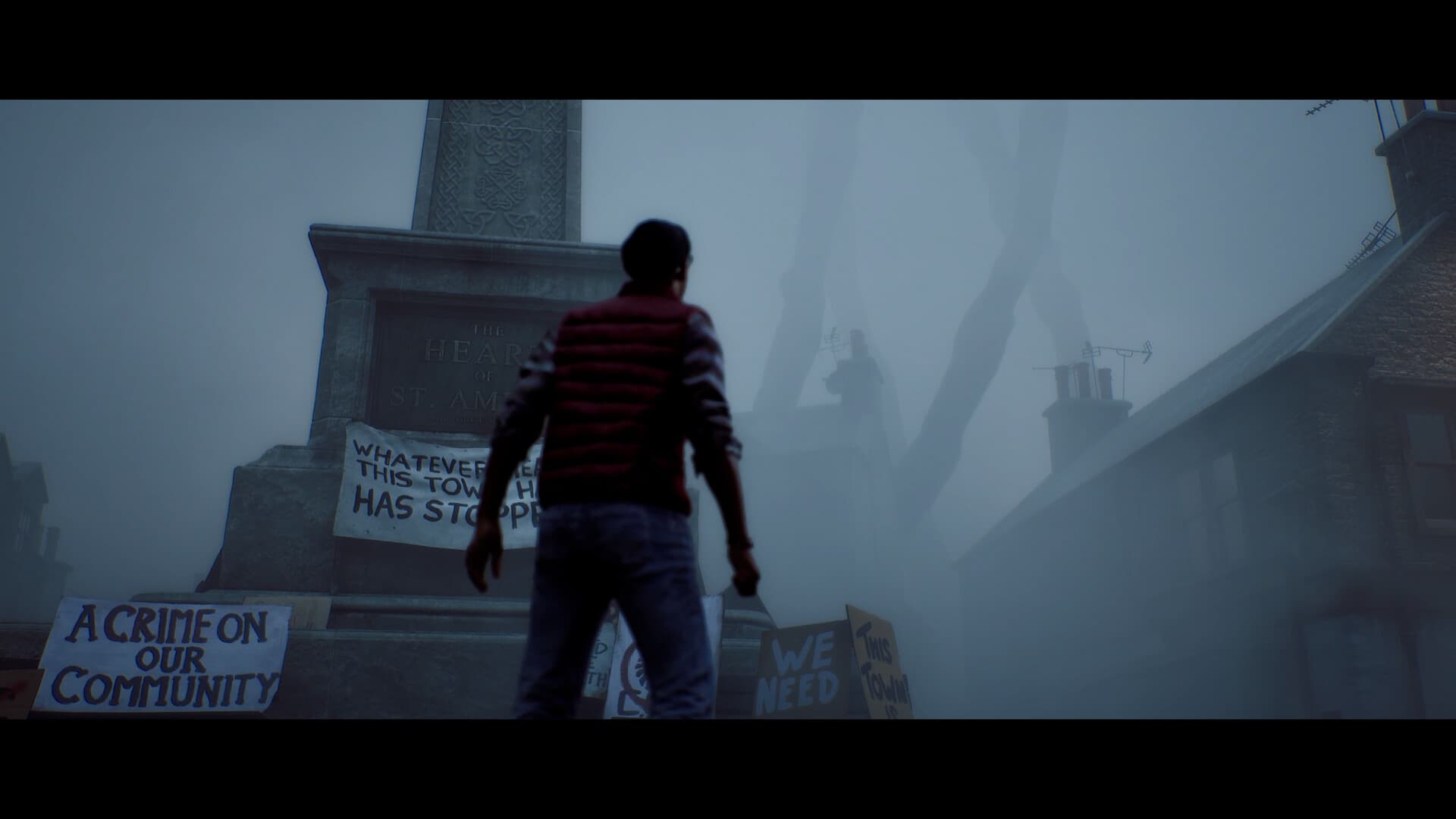 Simon stands before the Heart of St. Amelia monument in the foggy town square